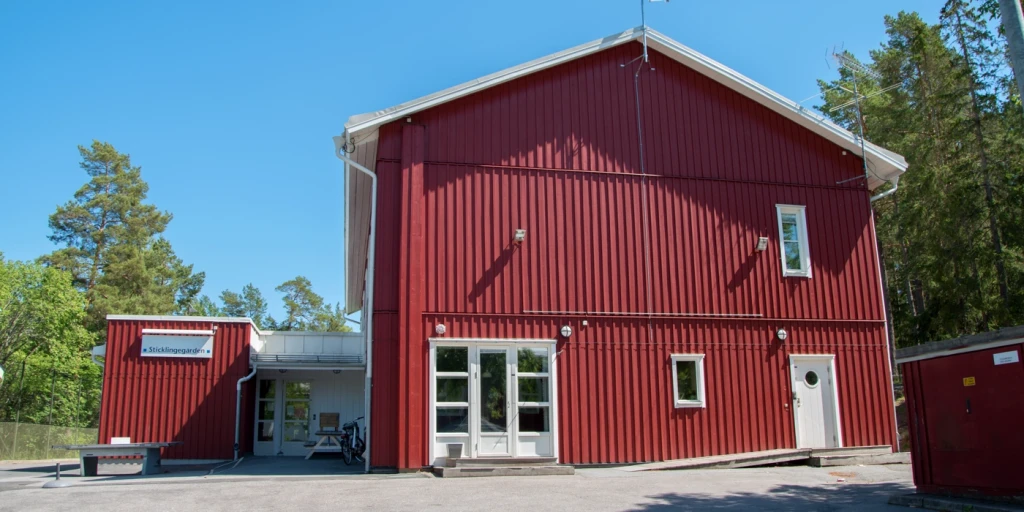 Sticklinge fritidsgårds röda byggnad med entré.