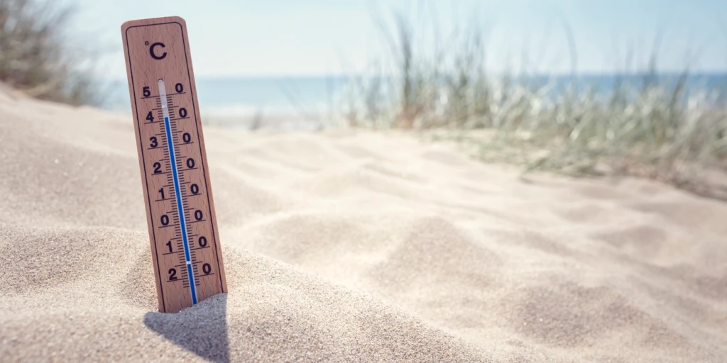 En termometer i sanden på en strand.