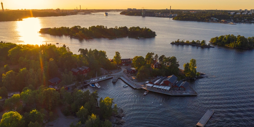 Flygfoto över skärgårdsöar i solnedgången.