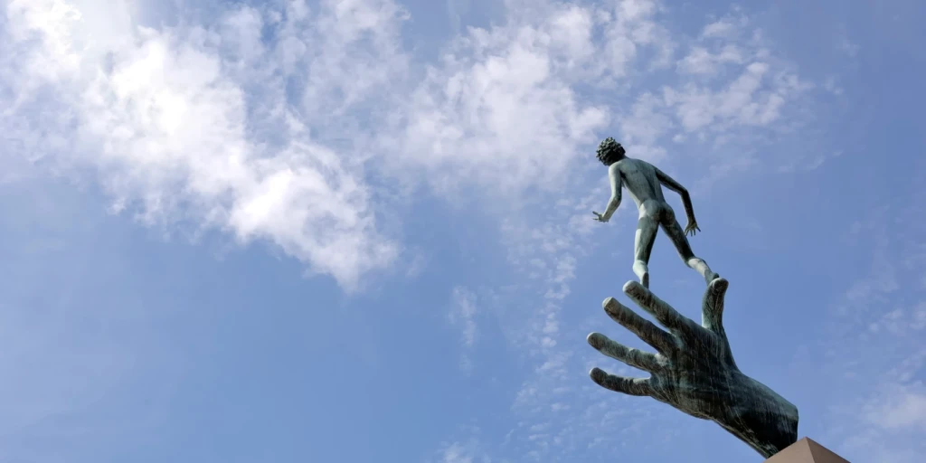 En skulptur med en man som balanserar på en hand.