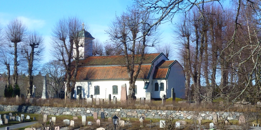 En kyrkogård med en kyrka i bakgrunden.