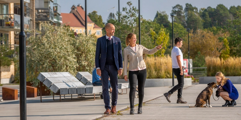 En grupp människor på ett gångstråk längs en kaj.