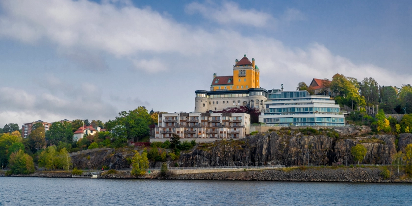 Stor borgliknande byggnad på ett berg vid vattnet.