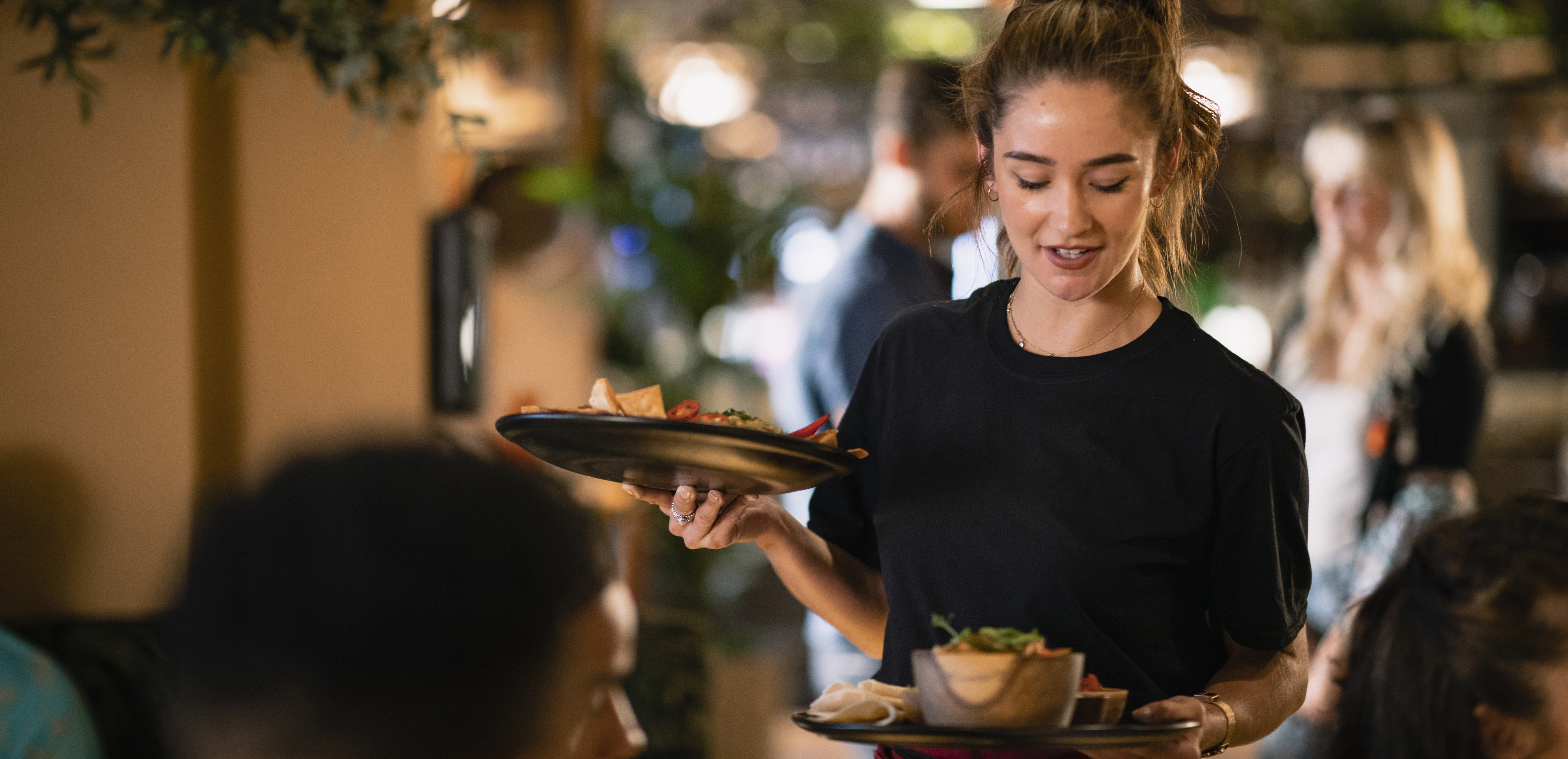 Tjej serverar mat på restaurang