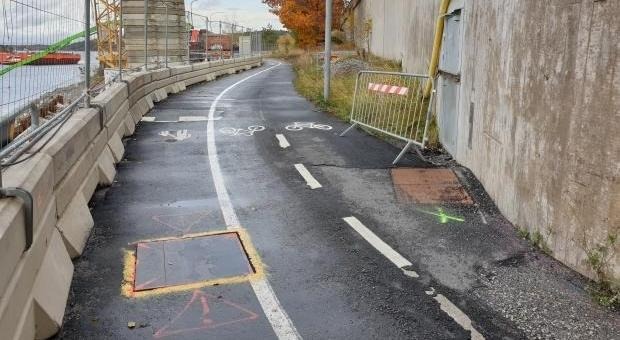 Gång och cykelväg med en markering vid en brunn