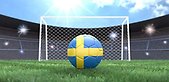 En fotboll med svenska flaggans färger på en fotbollsarena, ett fotbollsmål framför.