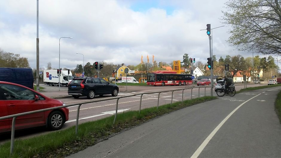 korsning med trafikljus, bilar och en cyklist. 