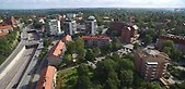 Drönarbild över stor väg med två broar, flerbostadshus vid sidan om vägen.