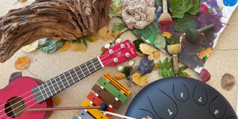 En ukulele och andra musikinstrument på ett bord.