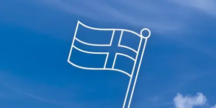 En vit flagga som vajar på den blå himlen.