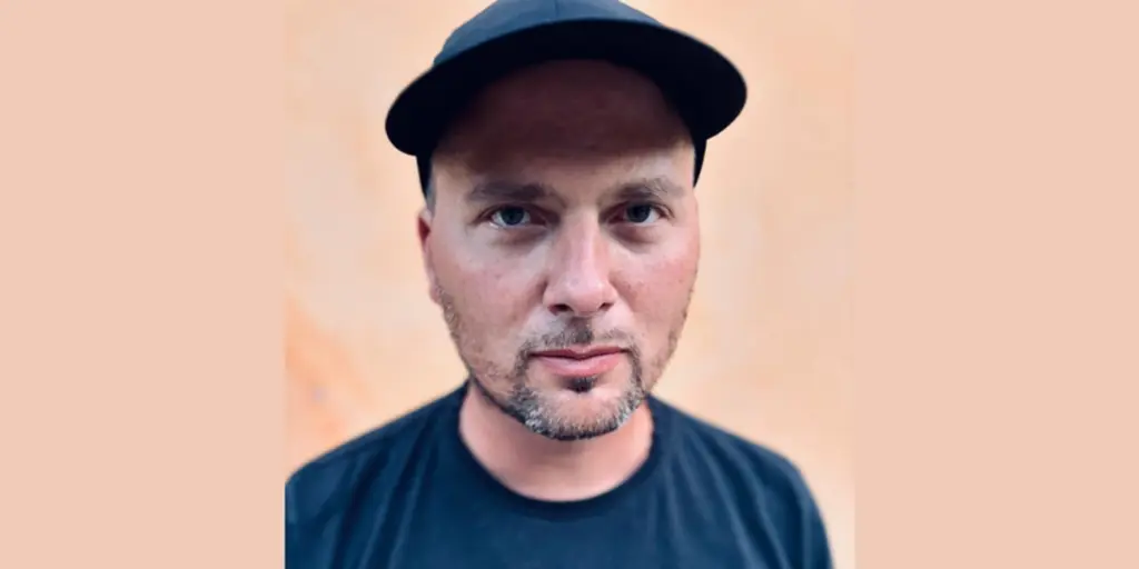 Porträtt av man med blå keps och lite skäggstubb