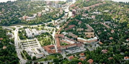 Flygfoto över en stadsdel med vatten och en bro i bakgrunden.