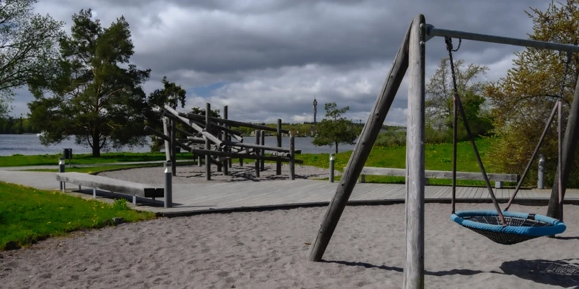 Lekpark med en klätterställning och en gungställning.