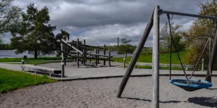 Lekpark med en klätterställning och en gungställning.