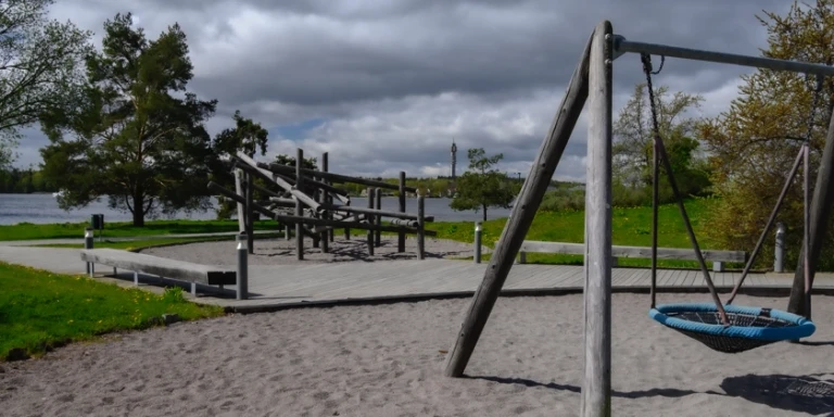 Lekpark med en klätterställning och en gungställning.
