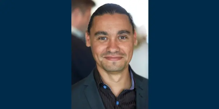 Närbild av Samir Sandberg som har mörkt hår och ler in i kameran 