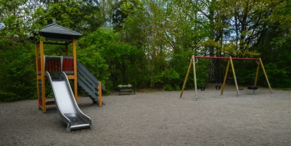 Lekpark med en rutschkana och en gungställning.