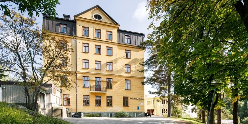 En stor gul byggnad med många fönster.