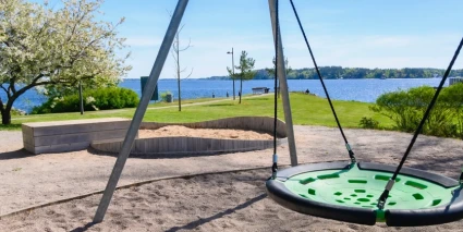 En lekpark med en kompisgunga nära havet.