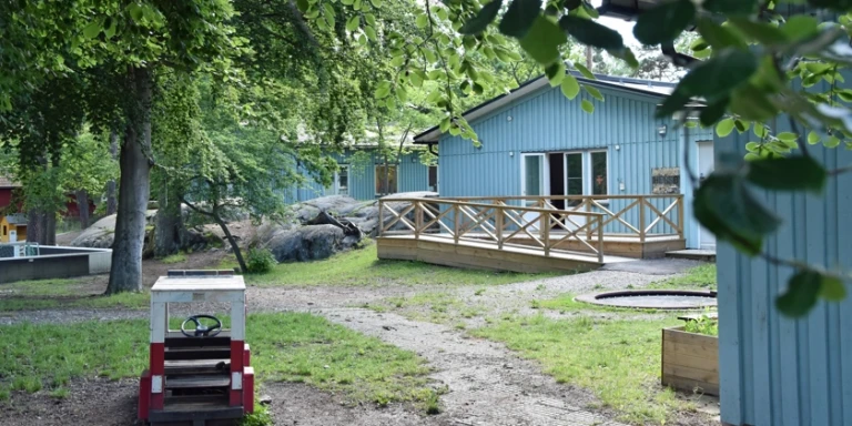Lummig utegård med lekbil på Hersby förskola. 