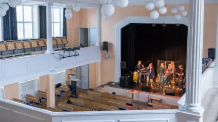 En utsikt från en balkong i en aula, mot ett band som spelar.