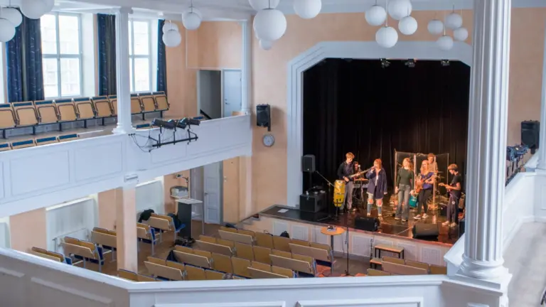 En utsikt från en balkong i en aula, mot ett band som spelar.