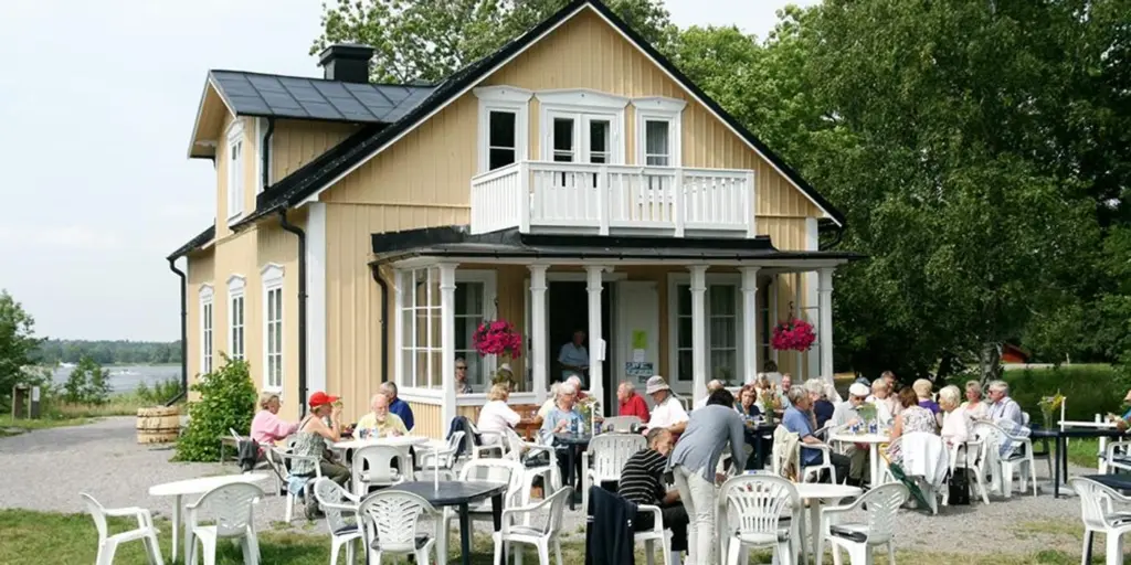 Gäster på en uteservering vid en gul villa.