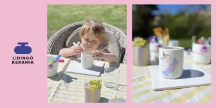 En liten flicka sitter vid ett bord med en enhörningsmugg.