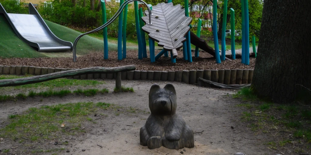 En lekpark med träskulpturer  i form av björnar.