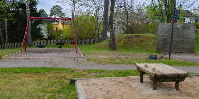 En lekpark med en gungställning och en sandlåda.