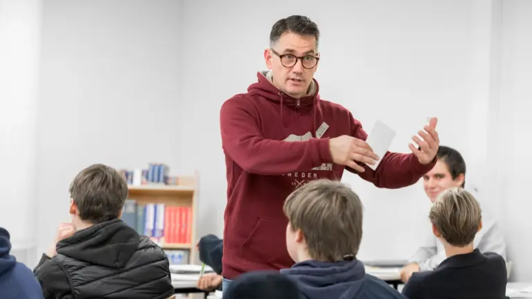 En man som undervisar i ett klassrum fullt av elever