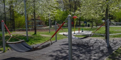 En lekpark med hängmattor omgiven av grönska.