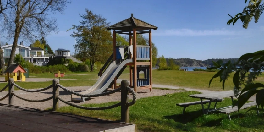 En lekpark med rutschkana nära vattnet.