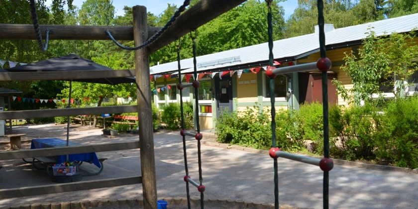 Utegården med klätterställning och vimplar på Näsets förskola.