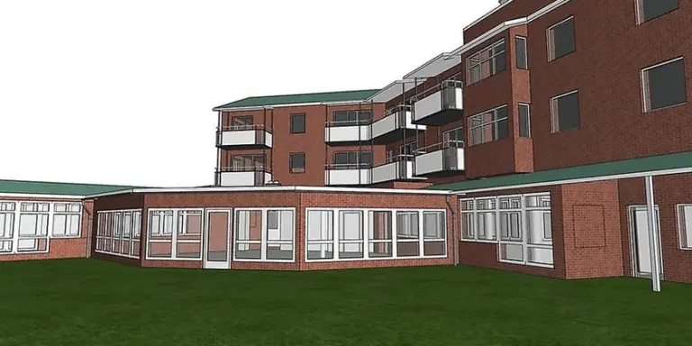 En arkitektbild av hur seniorboendet Tor kommer att se ut. En brun fasad med vita balkonger och fönster med vita karmar. 