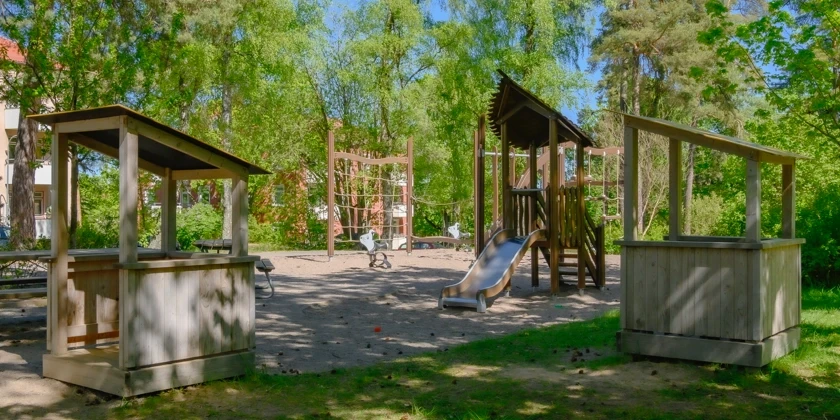 En lekpark bredvid flerbostadshus.