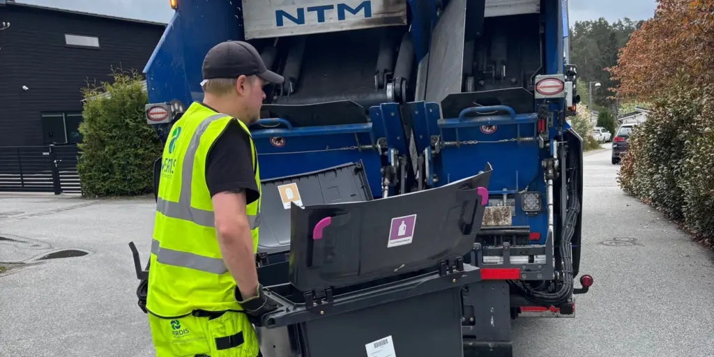Fastighetsnära hämtning av förpackningar för återvinning, av varselklädd renhållningsarbetare.