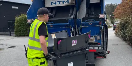 Fastighetsnära hämtning av förpackningar för återvinning, av varselklädd renhållningsarbetare.