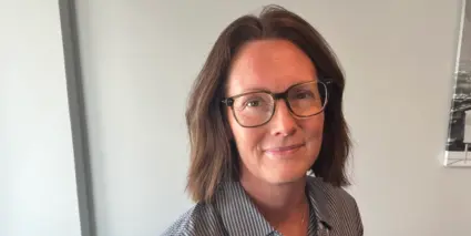 Porträtt av Lena Wennerklint sittandes vid ett bord. 