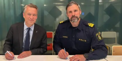 Stadsdirektör och polisman sitter vid ett bord och skriver under samverkansavtal.
