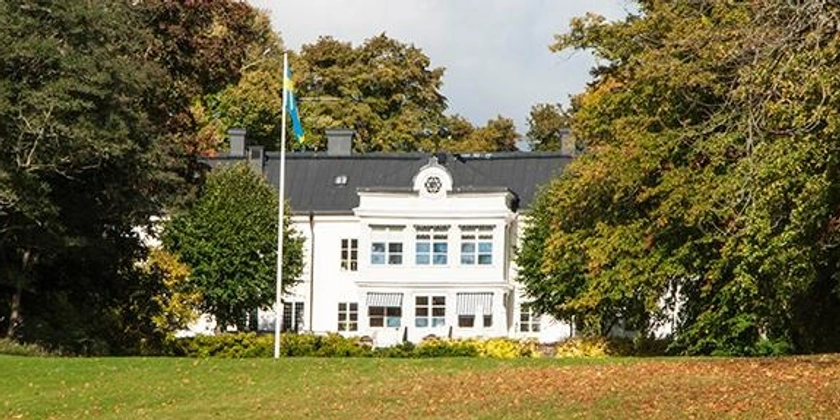 En stor herrgård omgiven av en park.