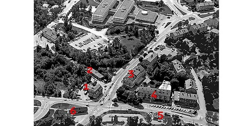 Ett svartvitt flygfoto av en stadsdel markerat med röda siffror.
