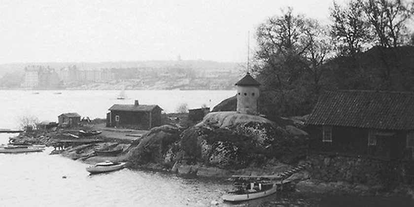 Ett svartvitt foto av ett litet kastell på en ö. 