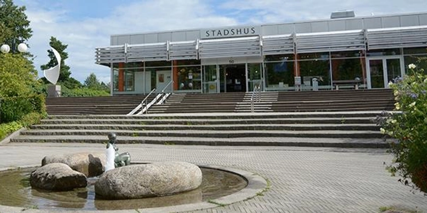 Ett stadshus med en fontän i förgrunden.