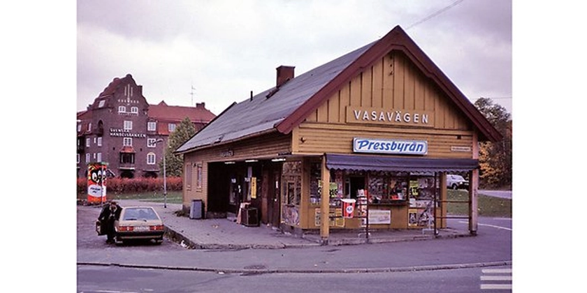 Ett äldre foto på en Pressbyrå med en bil parkerad bredvid.