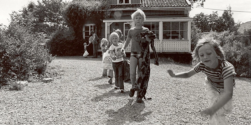 Ett svartvitt foto av barn som ska gå och bada.