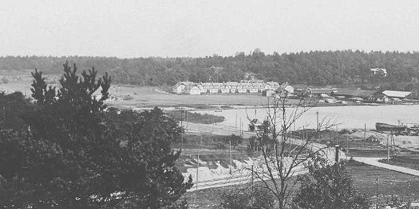 Ett svartvitt foto av ett bostadskvarter vid vattnet.