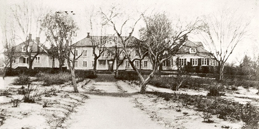 Ett svartvitt foto av en väg upp till en gård.