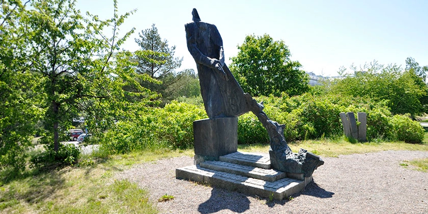 En skulptur i brons, nära fyra meter hög som föreställer Raoul Wallenberg som räcker skyddspass till hotade människor.