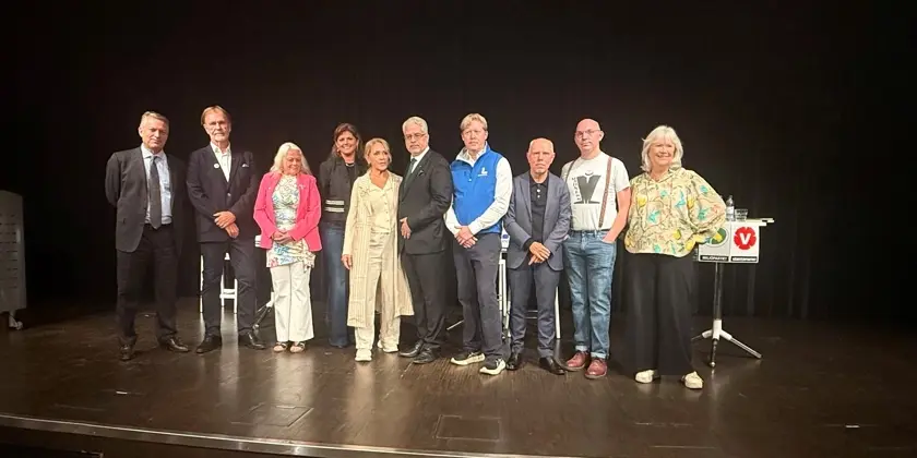 En grupp politiker som står uppe på en scen.